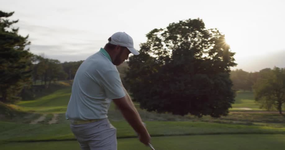 A man on the golf course hits a drive