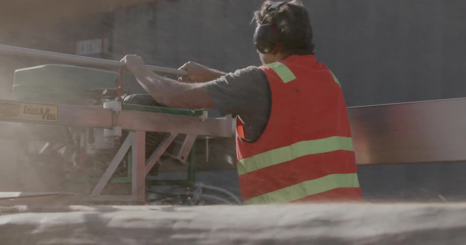 A man has to look away from the dust blown up by a piece of equipment