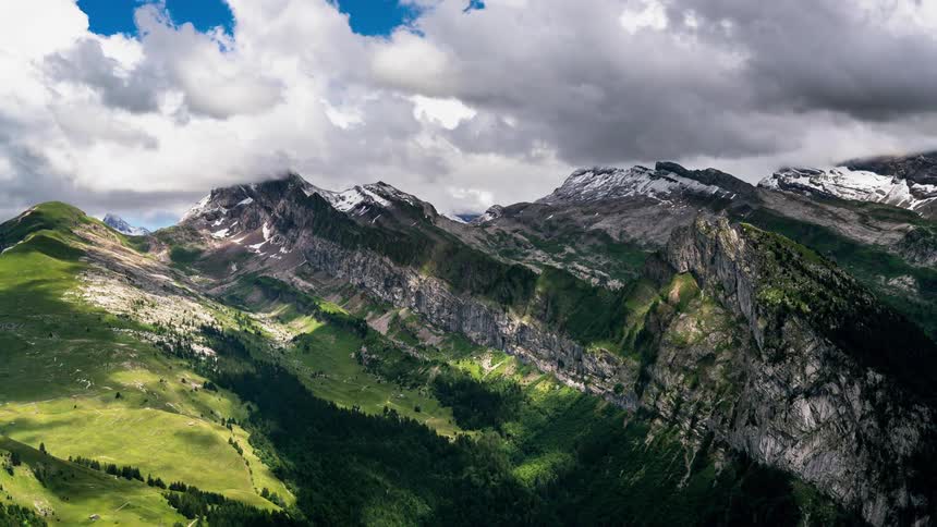 Clouds pass above the jagged mountain tops of the French Alps