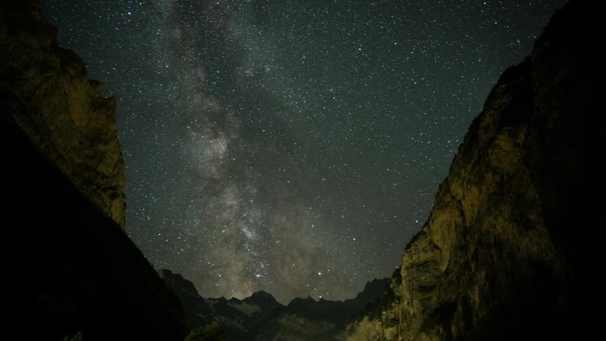 The night sky between the mountain has many stars