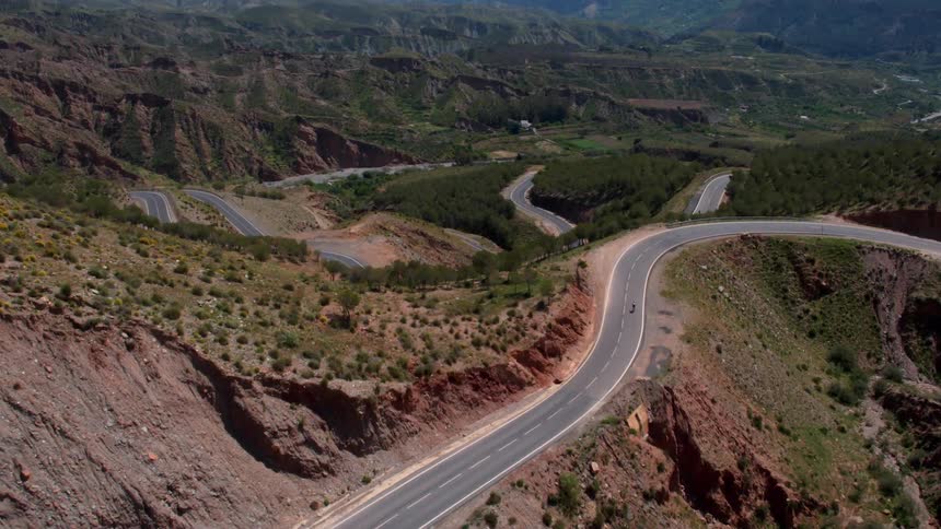 A bicyclist rides down a mountain road in the south of Spain