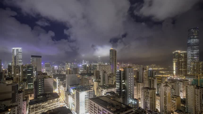 Clouds passing over a brightly lit city