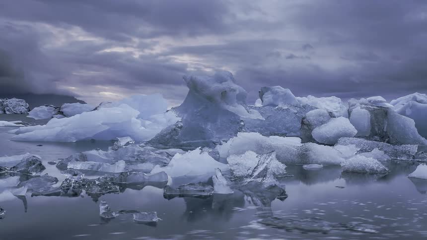 The ice floats around all over the water on a cloudy day