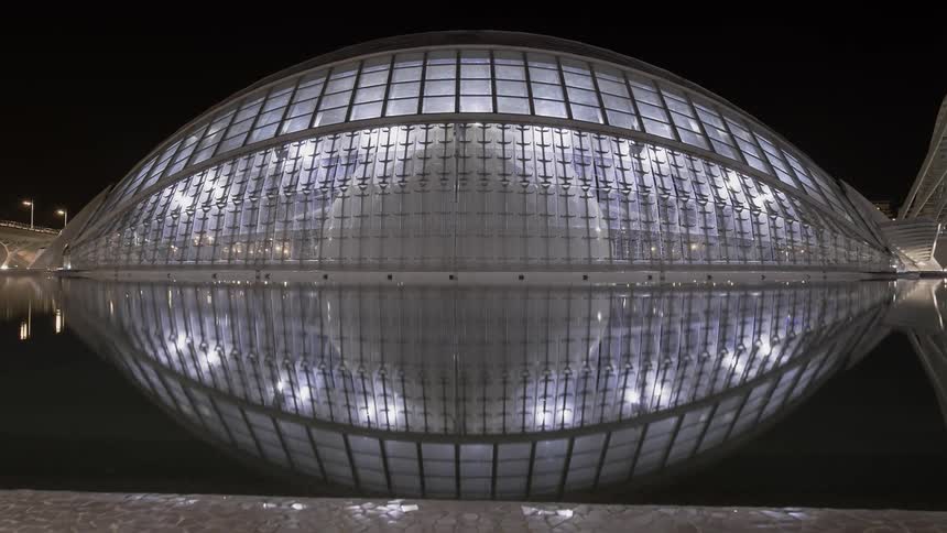 A large glass shaped building at night