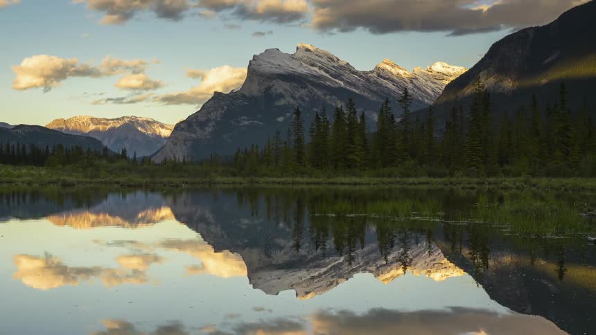 Clouds pass by above Vermillion lakes surrounded by the Rocky mountains in Banff, Canada
