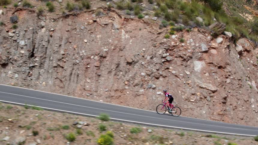 Man riding his bike on a twisting road up the Sierra Nevada mountain range