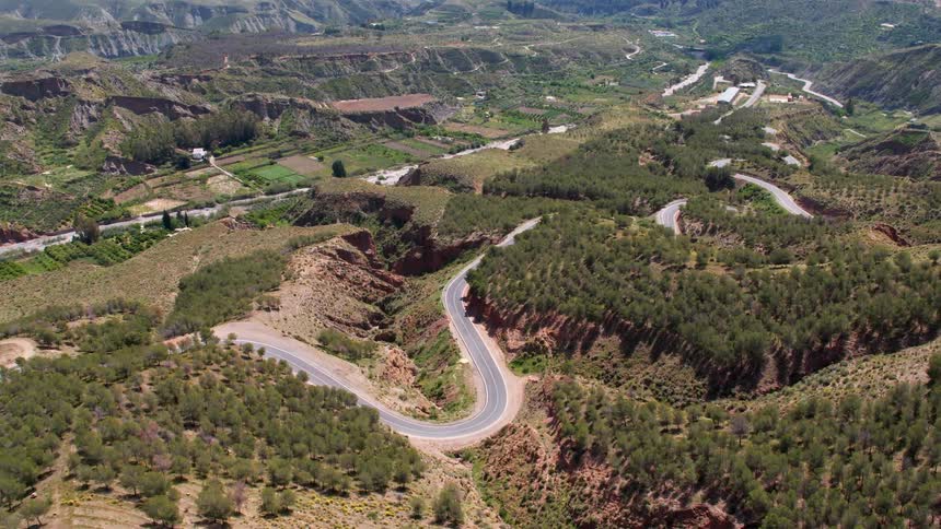 Road going through a valley near the mountains around Granada, Spain