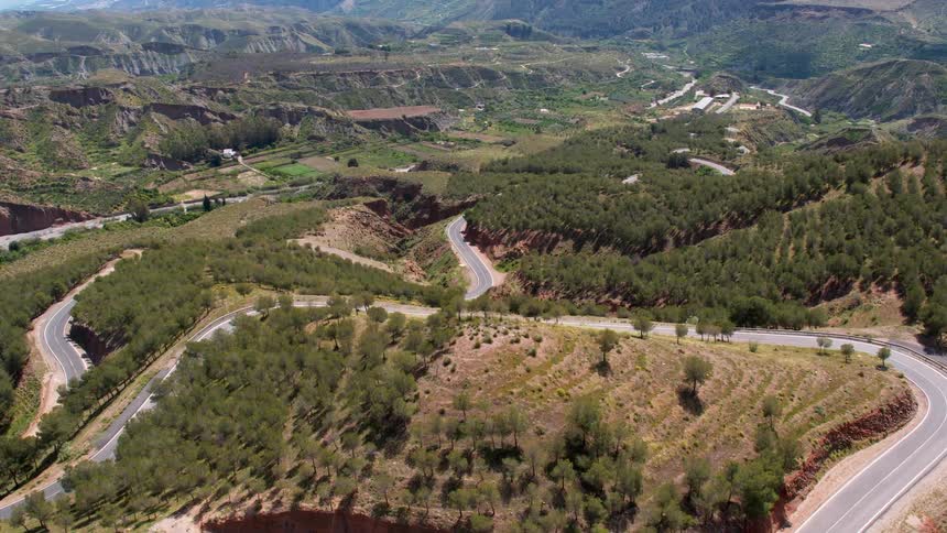 The road winds around the scenic hills of northern Spain