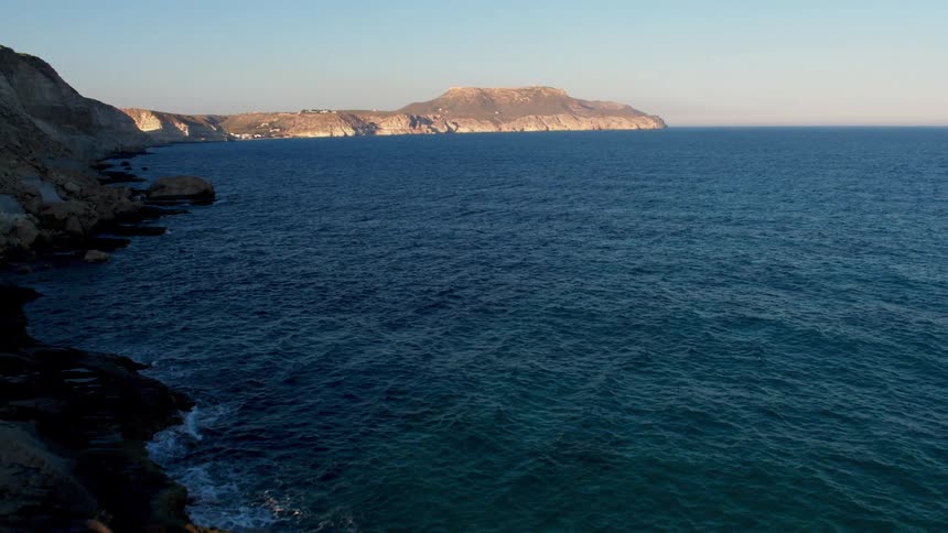 Flying over the calm Atlantic ocean with rocky shores