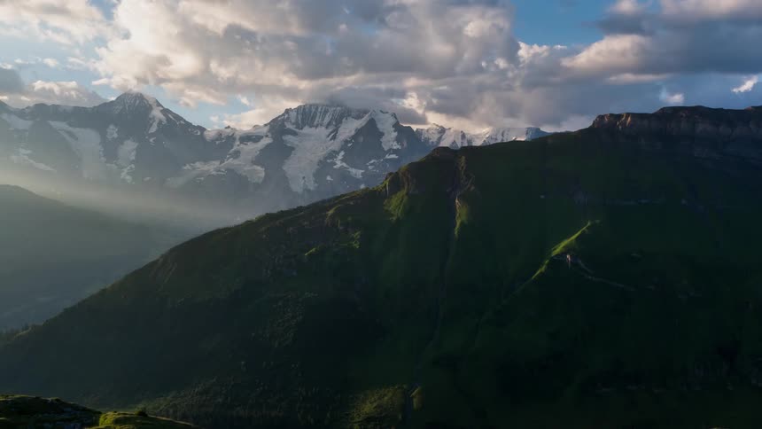 Clouds hang over the tall mountains