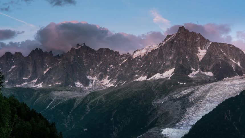 Clouds rolling over snowy mountain tops