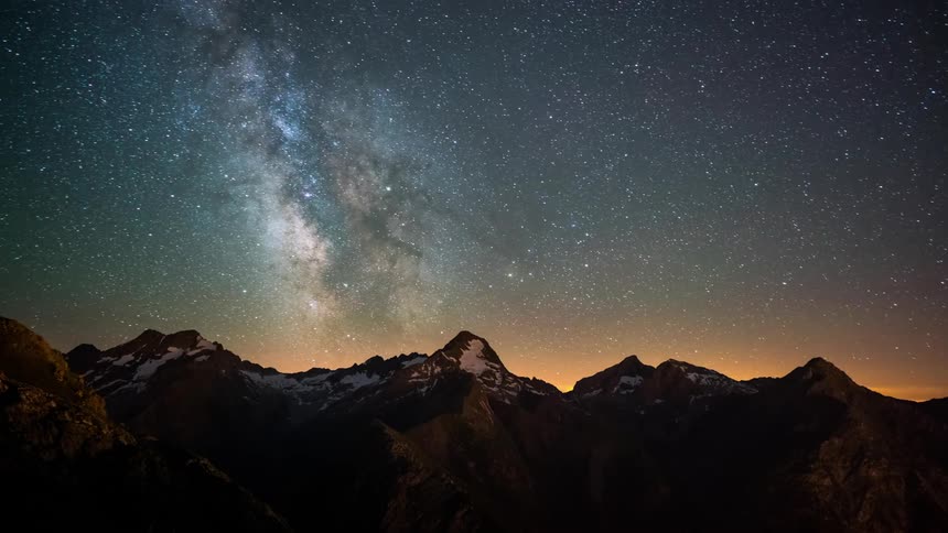The stars and milky way pass above the scenic Alps at night