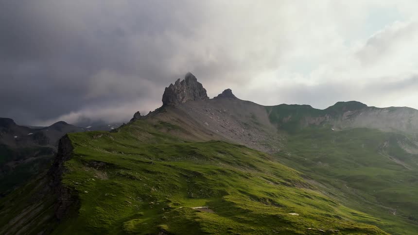 Storm clouds are moving over a mountain ridge during the day