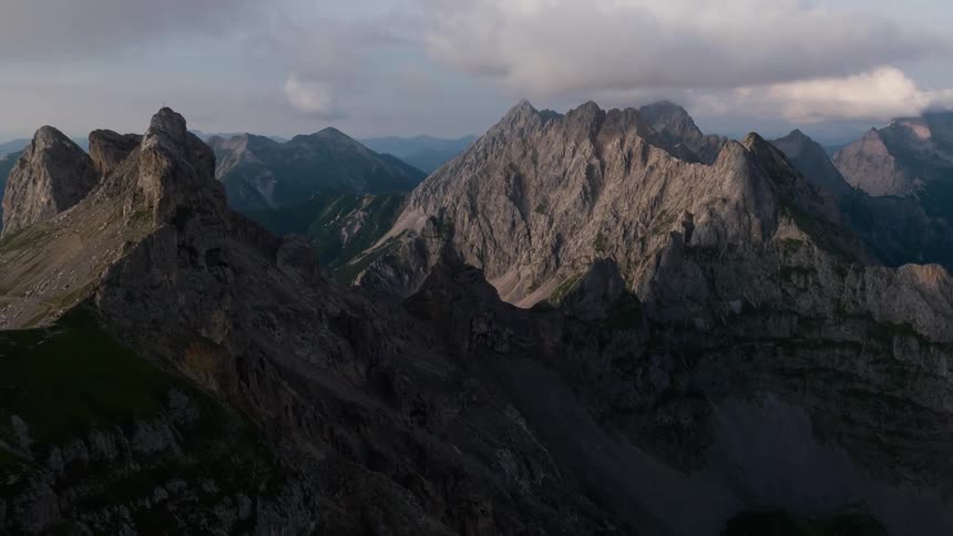 Clouds hang above tall mountains