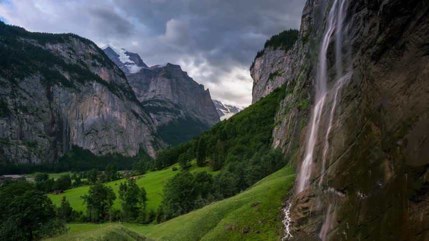 The waterfall is pouring water in the green valley