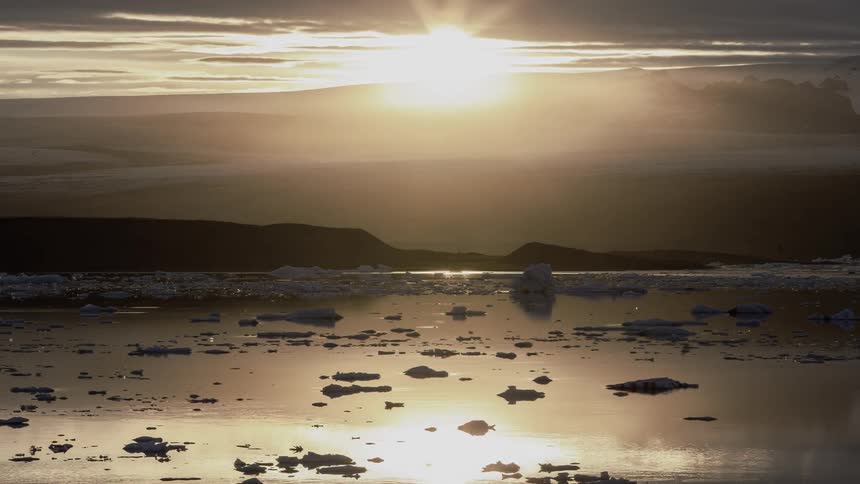 Icebergs float on the water as the sun shines