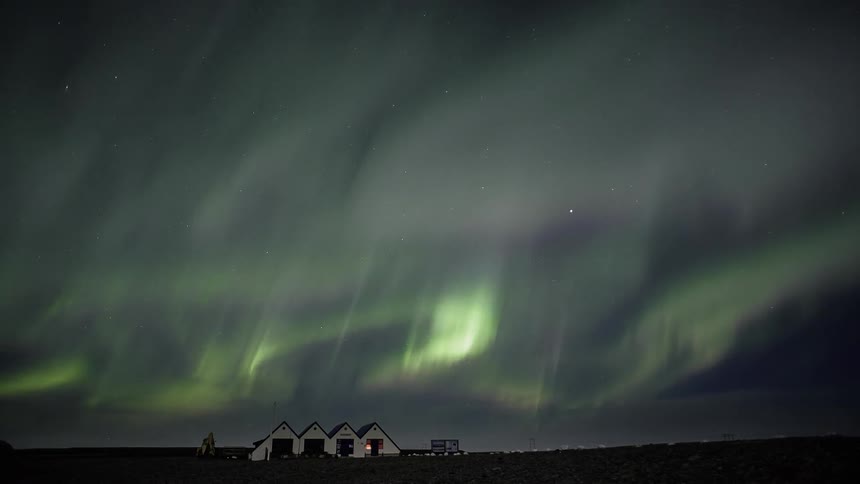 Time lapse of the aurora dancing above a farmhouse