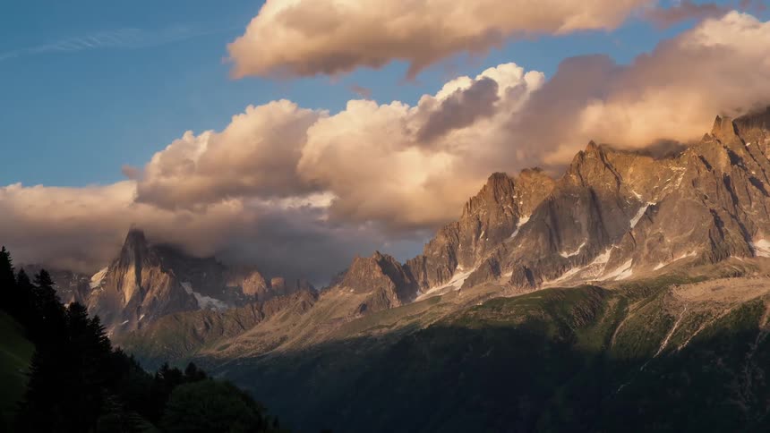 Clouds are hanging above mountain peaks at dawn