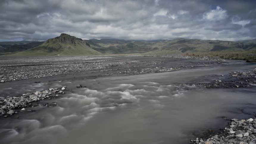 Water flows down the stream as clouds pass above