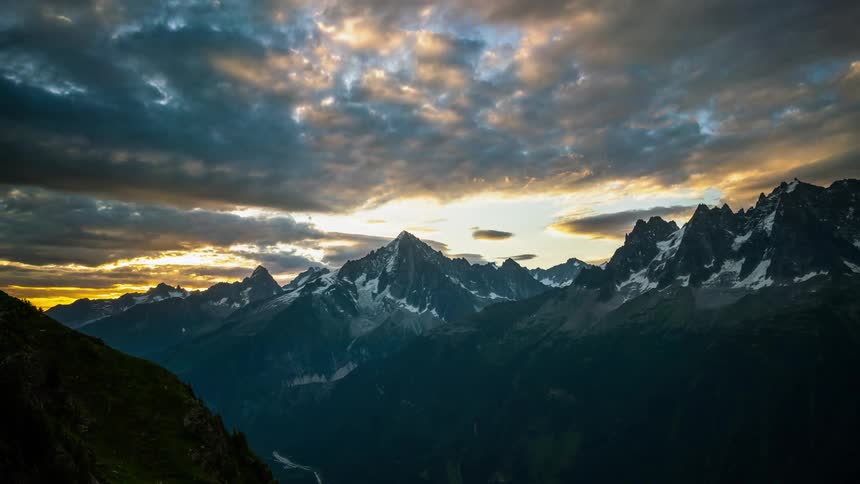 The sunrise glows orange and yellow over the mountains