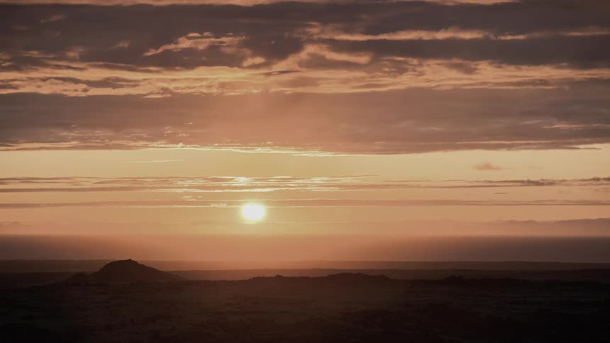 The sun shines brightly and sets as clouds pass