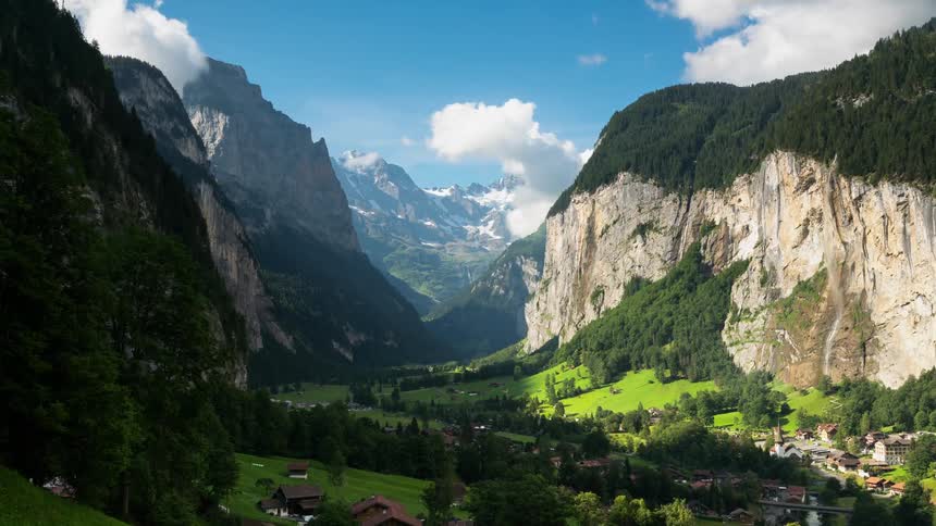 The mountains are providing shade to the trees and homes below