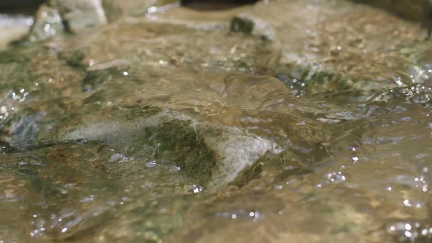 Water flowing over brown rock