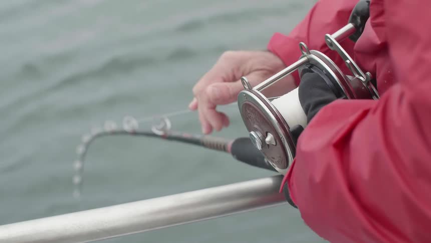 A fisherman lets out a fishing line
