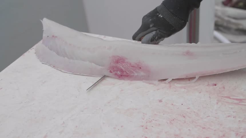A man is cutting a fish on the table