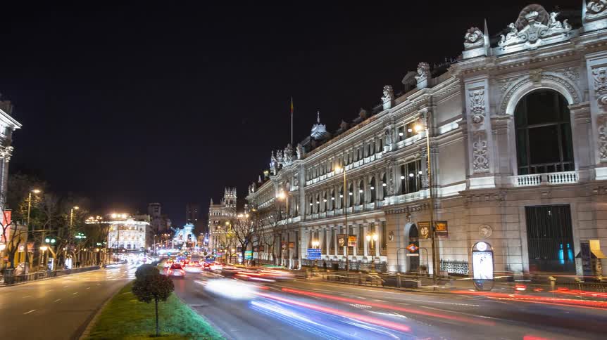 Cars drive on a city street at night