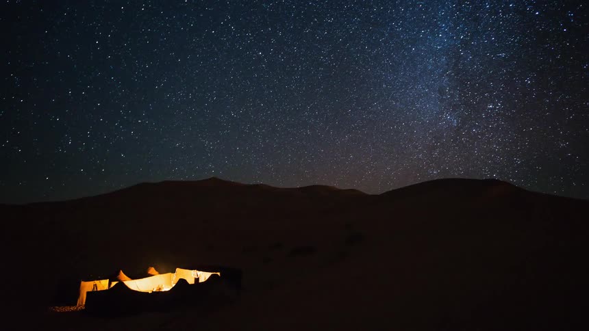 People camp beneath a starry night sky