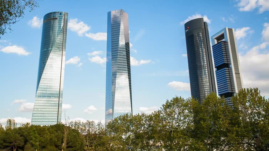 Four skyscrapers with clouds rolling overhead