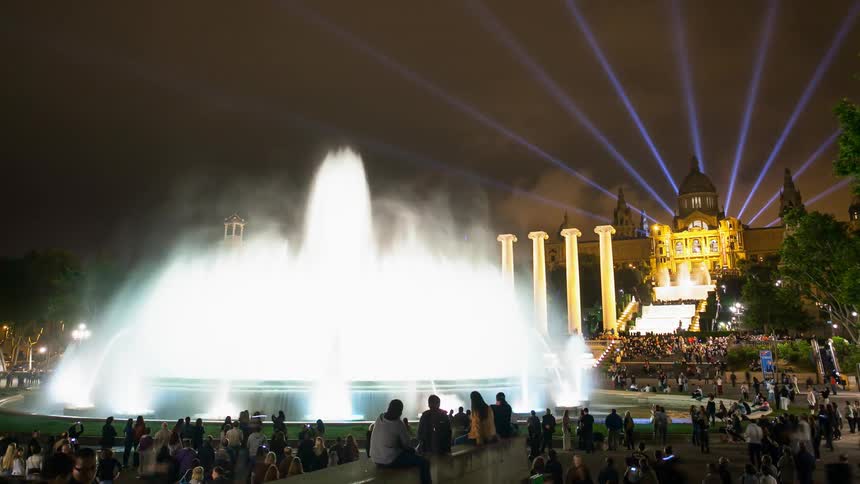Time lapse of a crowd gathered around a large fountain at night