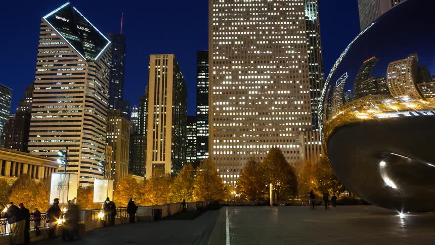 Tourists walk around the bean sculpture in chicago at night