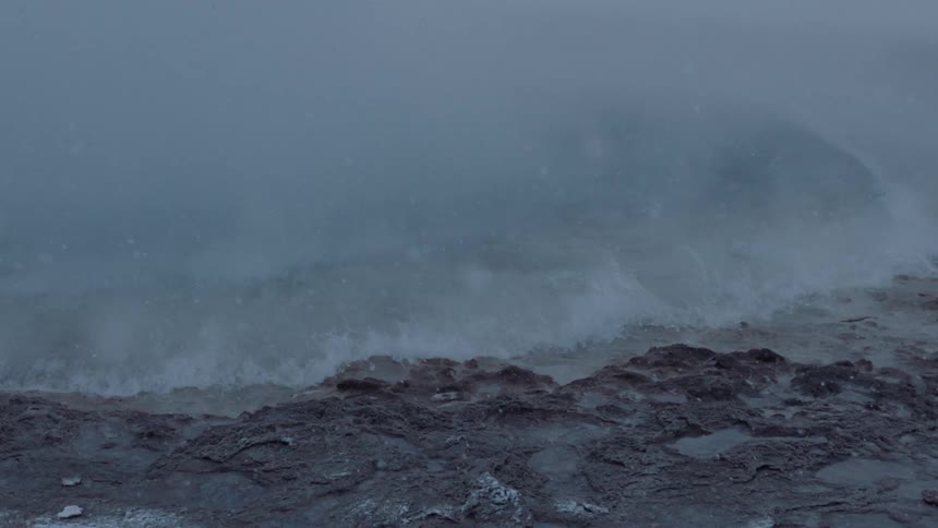 Snow falls as water erupts on a lake