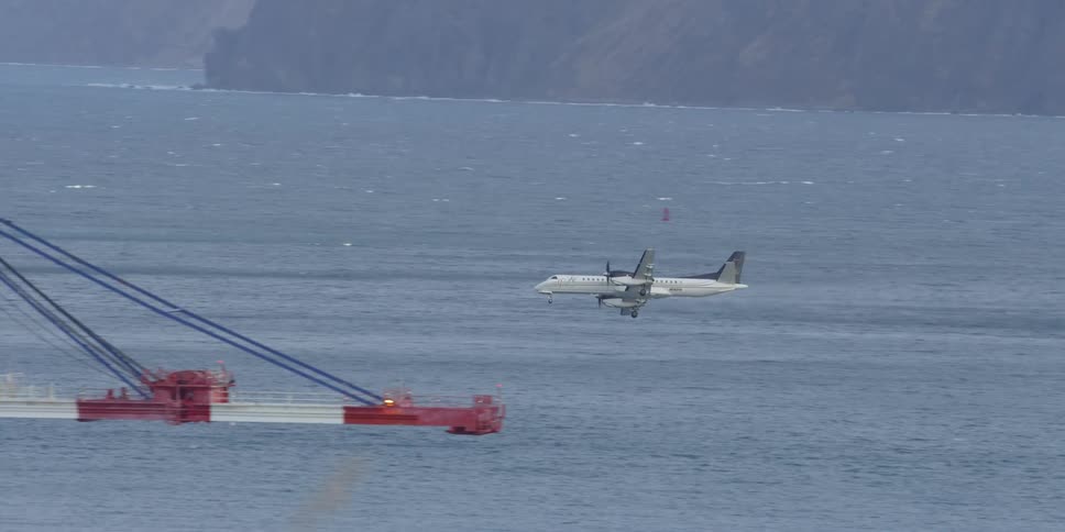 A plane descends over the water ahead