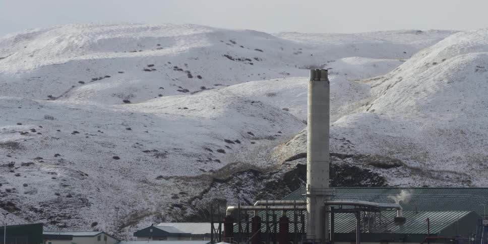 Smoke pours from an industrial building in the snow