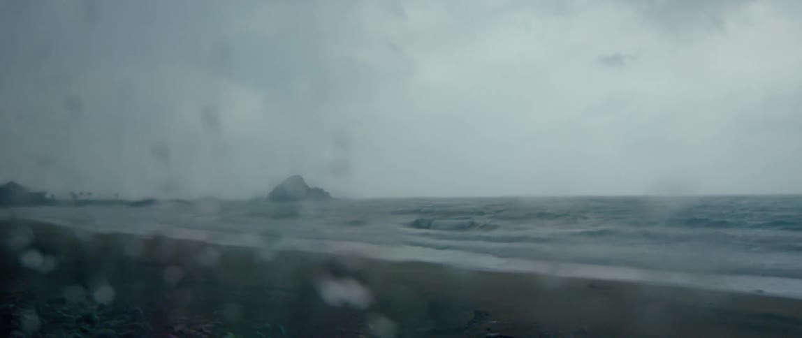 Water drops sit on glass as ocean waves come to shore