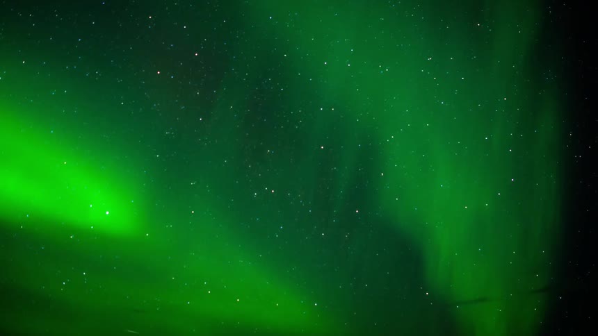 Time lapse of bright green auroras are swirling in the night sky