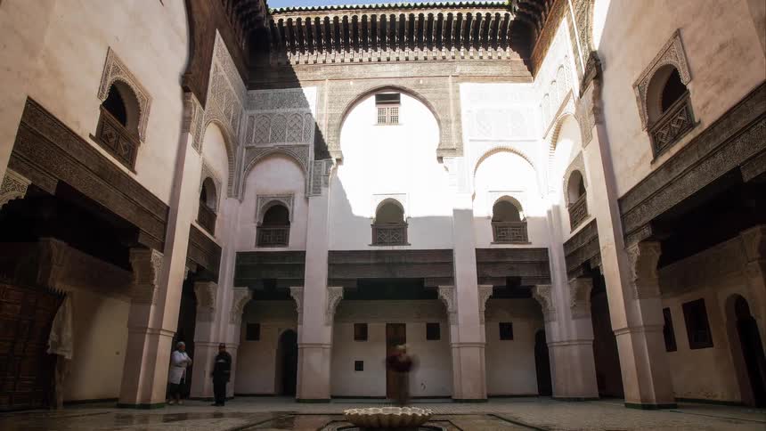 People walk through a courtyard of a mosque