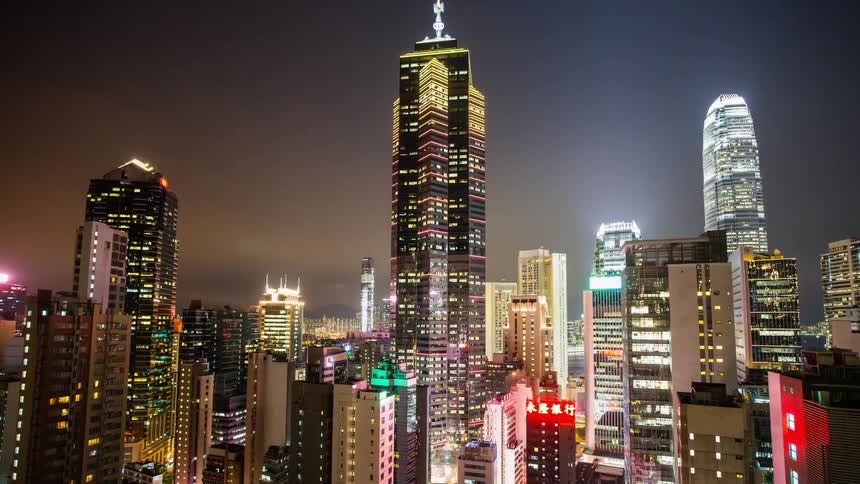 Multiple colored lights shining on many skyscrapers at night