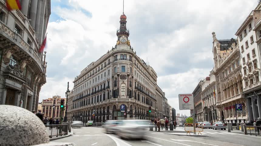 Pedestrians and cars commute on a city street