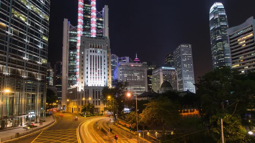 The cars speed along the roads in the city at night