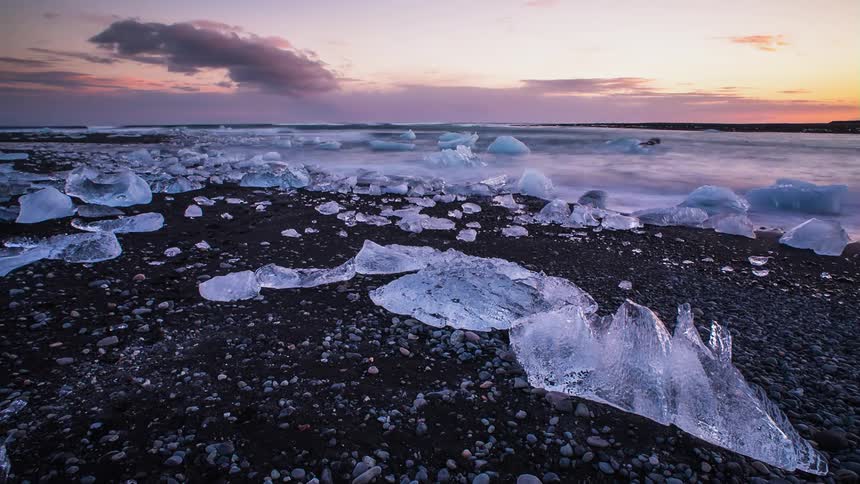 Water flows on an icy lake at sunset