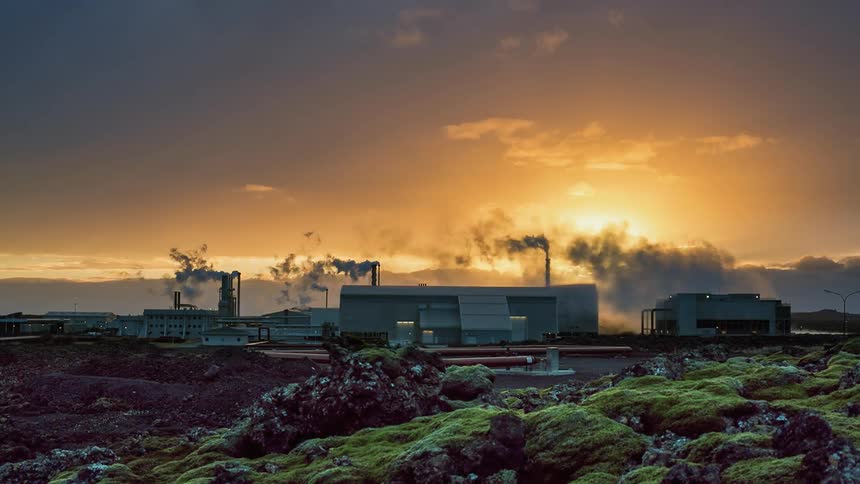 Time lapse of the sun rising over a factory