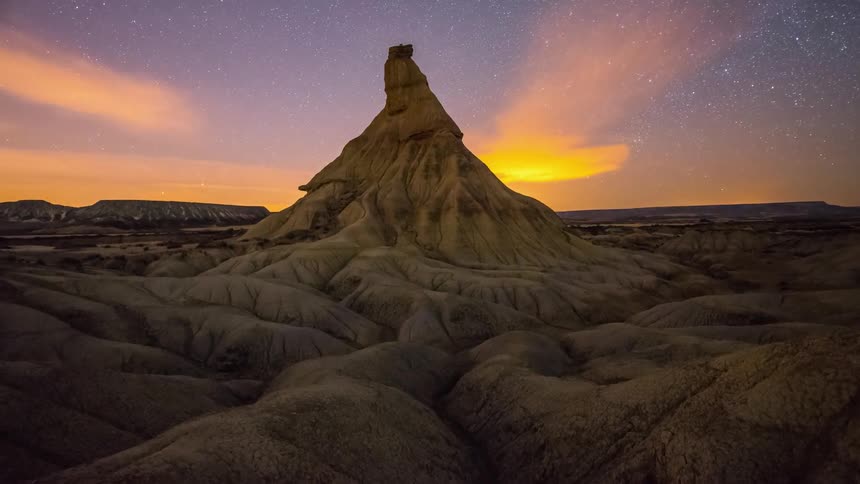 The sun sets over rock formations in the desert