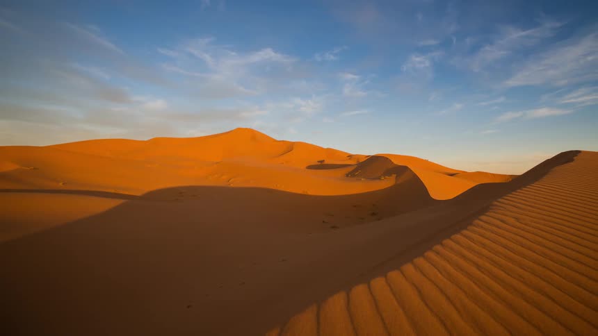 Clouds pass over vibrant sands in the Sahara desert