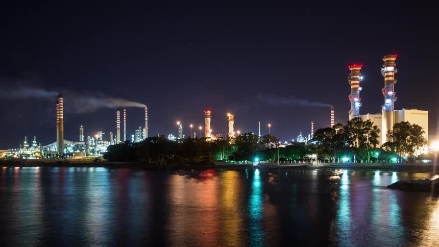 Wind blows the smoke from factory smokestacks at night