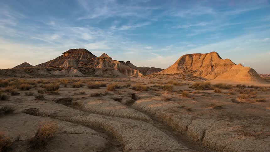 Clouds pass over rock formations in a desert