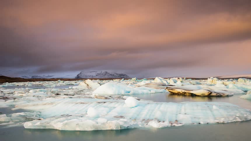 Ice floats on a lake at sunset